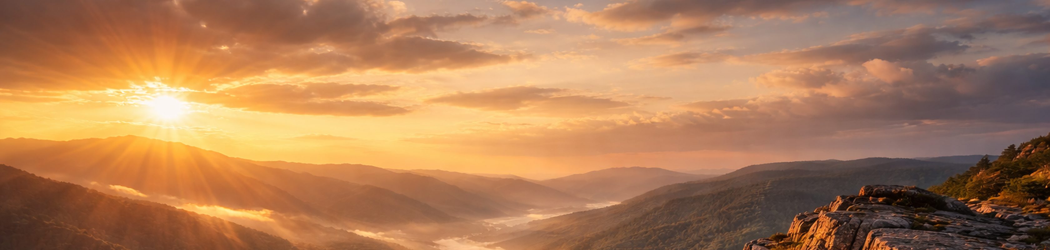 Sonnenaufgang über bewaldeter Bergkette im goldenen Morgenlicht